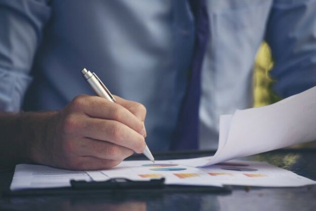 Man with pen writing a business plan