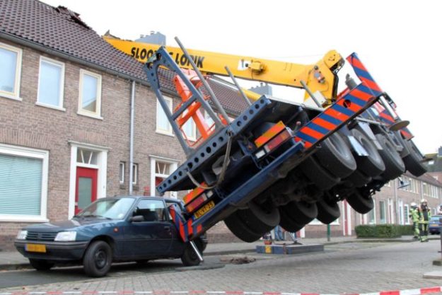 Crane topples on to house
